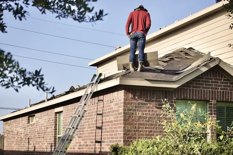 Professional roofer working on a residential roof in Eads